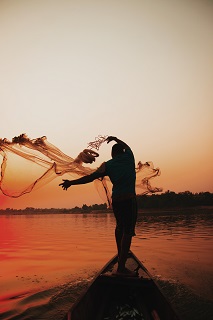 Photo by Ameer Umar: https://www.pexels.com/photo/silhouette-of-man-casting-net-in-water-13747516/